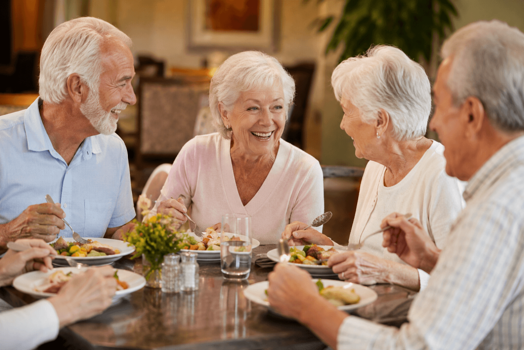 Senior residents enjoying a chef-prepared meal together in the dining room at American Orchards in Gilbert, AZ
